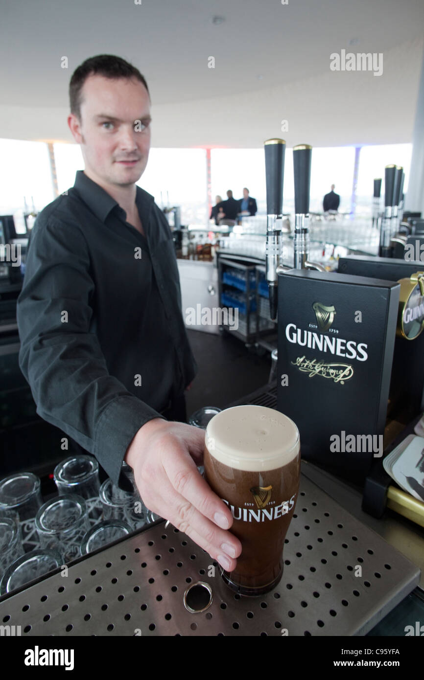 Repubblica di Irlanda, Dublino Guinness Storehouse, barman versando Guinness al Gravity Bar Foto Stock