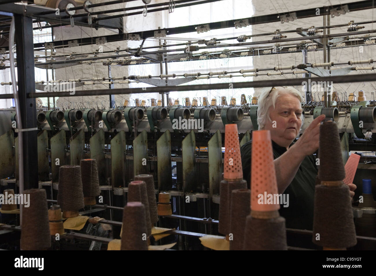 La Scozia, New Lanark, Donna filettatura di regolazione sul mulo di filatura macchina Foto Stock