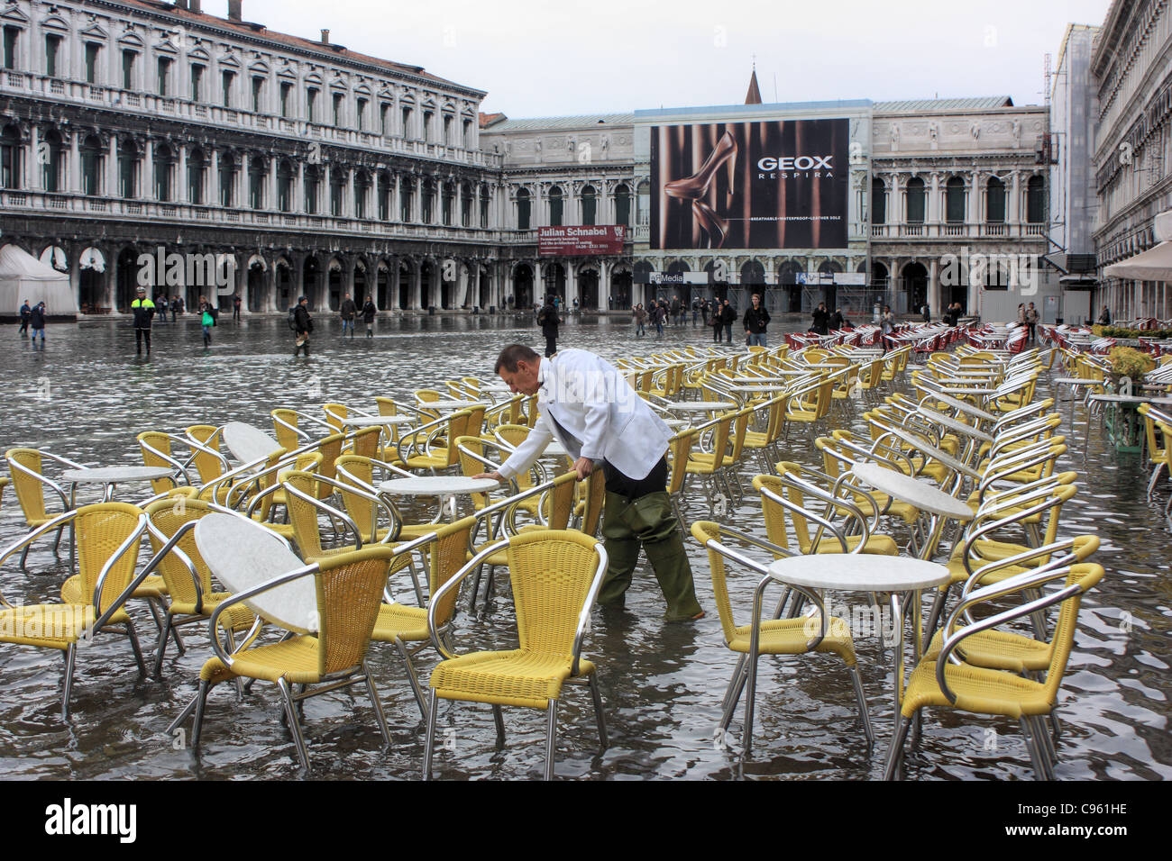 A preparare i tavoli per gli ospiti. -- Acqua alta in piazza San Marco, Venezia, Italia Foto Stock