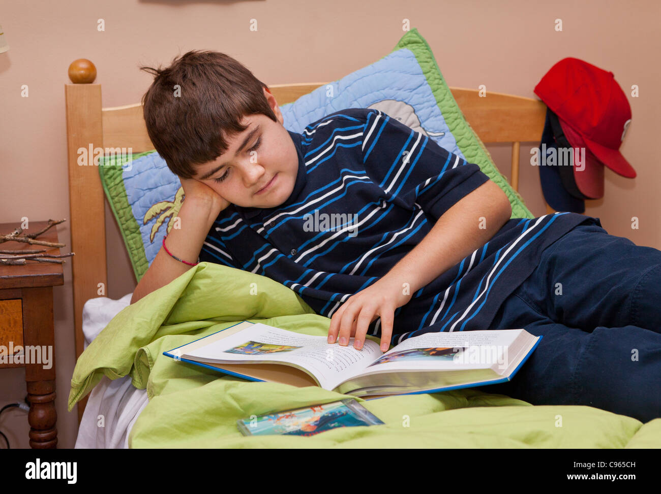 Ragazzo autistico, 13 anni, la lettura sul letto. Foto Stock