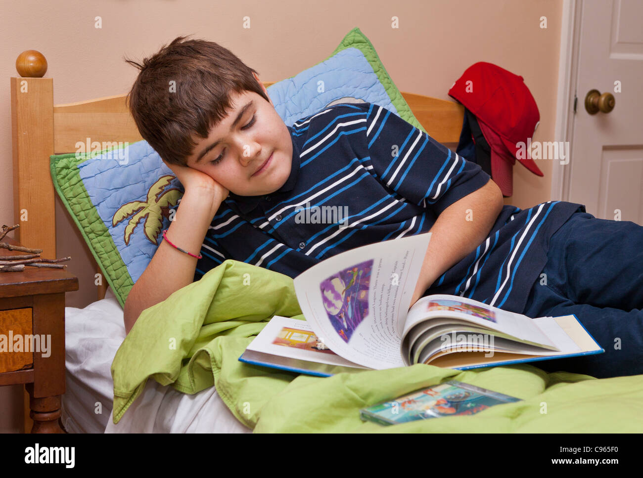 Ragazzo autistico, 13 anni, la lettura sul letto. Foto Stock