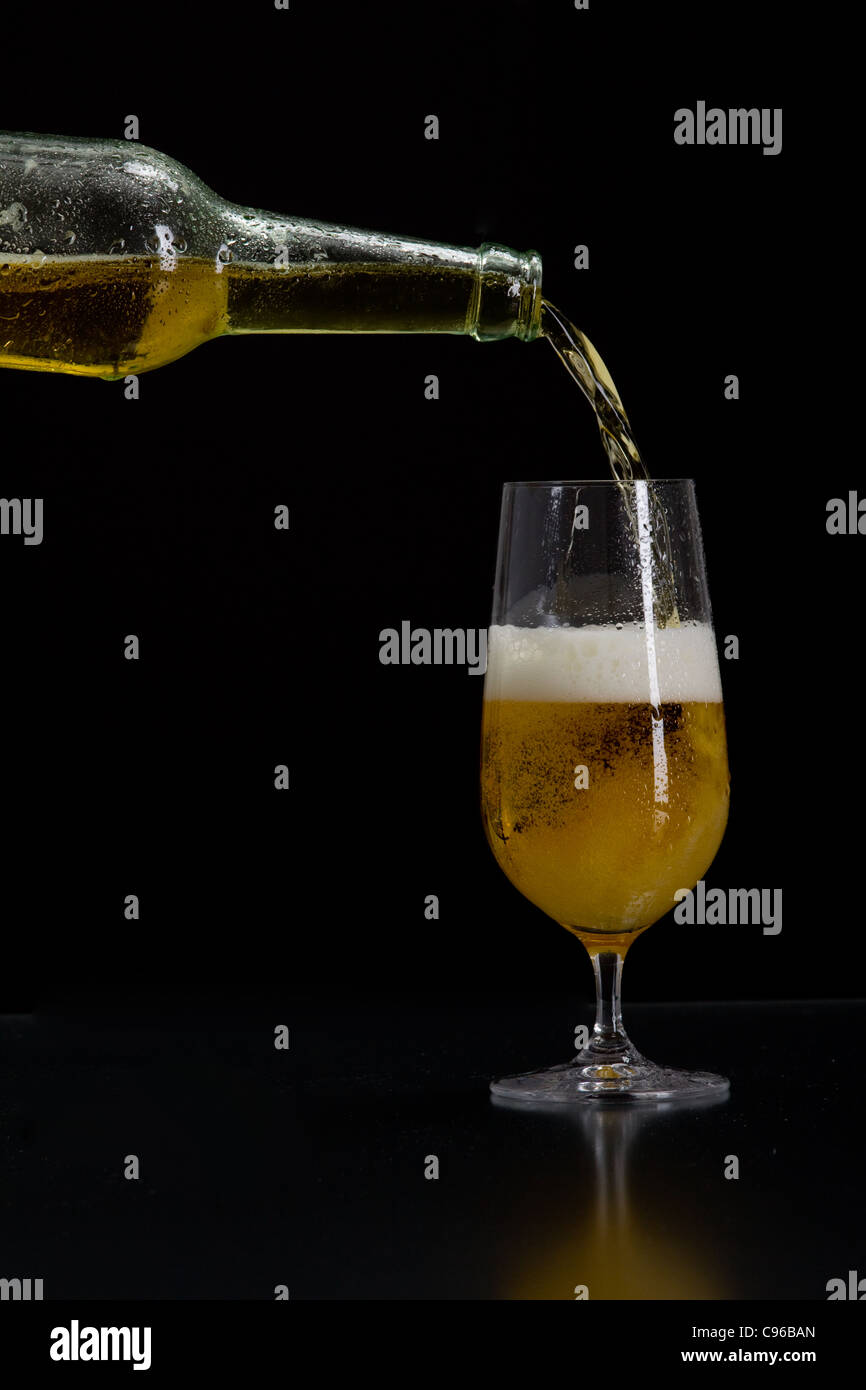 La birra viene versata in un bicchiere Foto Stock