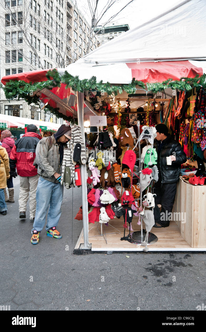 Diverse folla multietnica calorosamente gli acquirenti vestito Sfoglia articoli da regalo in vacanza outdoor mercatino di Natale i negozi di Union Square Foto Stock