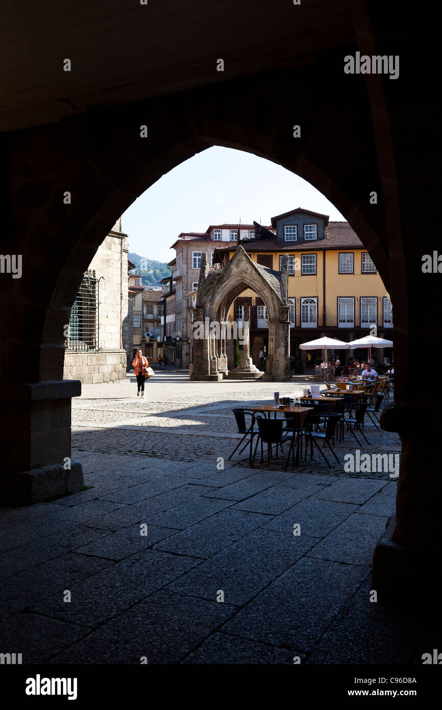 Oliveira Square, Salado monumento e di Nossa Senhora da Oliveira Chiesa visibile attraverso il vecchio Municipio arcade. Guimaraes, Portogallo Foto Stock