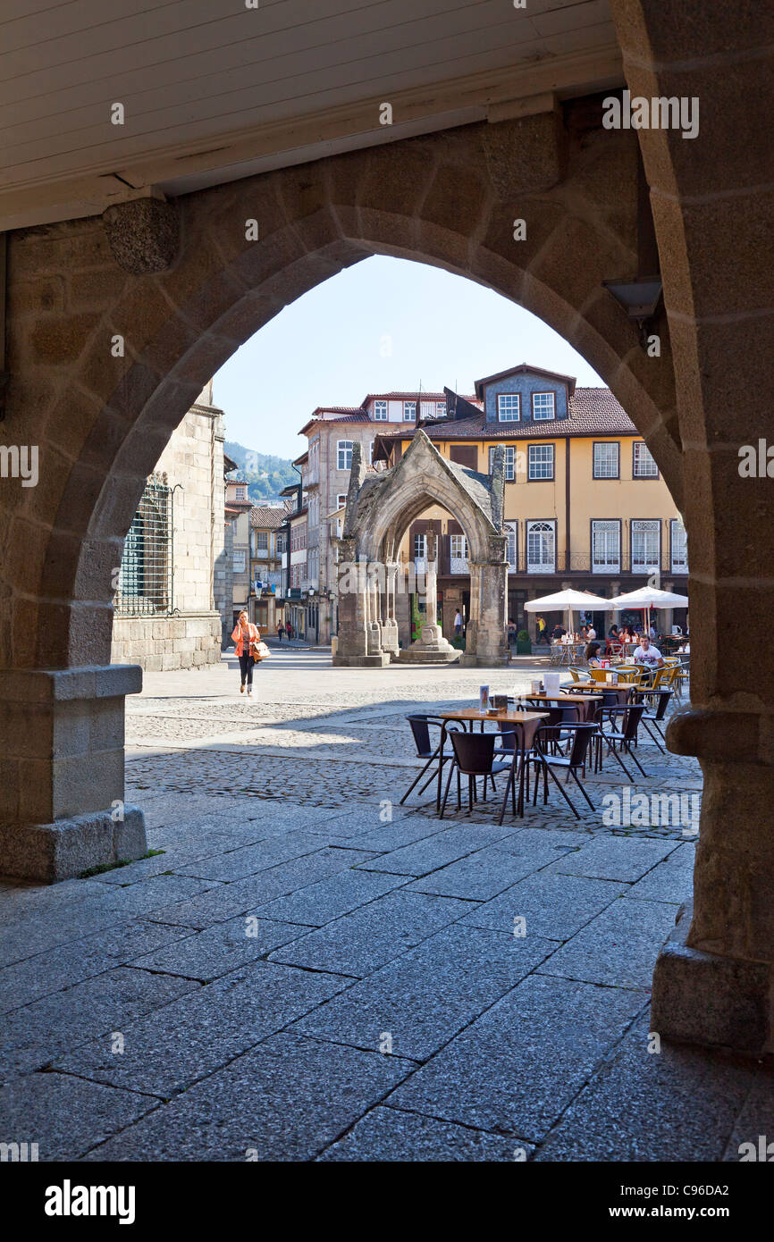 Oliveira Square, Salado monumento e di Nossa Senhora da Oliveira Chiesa visibile attraverso il vecchio Municipio arcade. Guimaraes, Portogallo Foto Stock