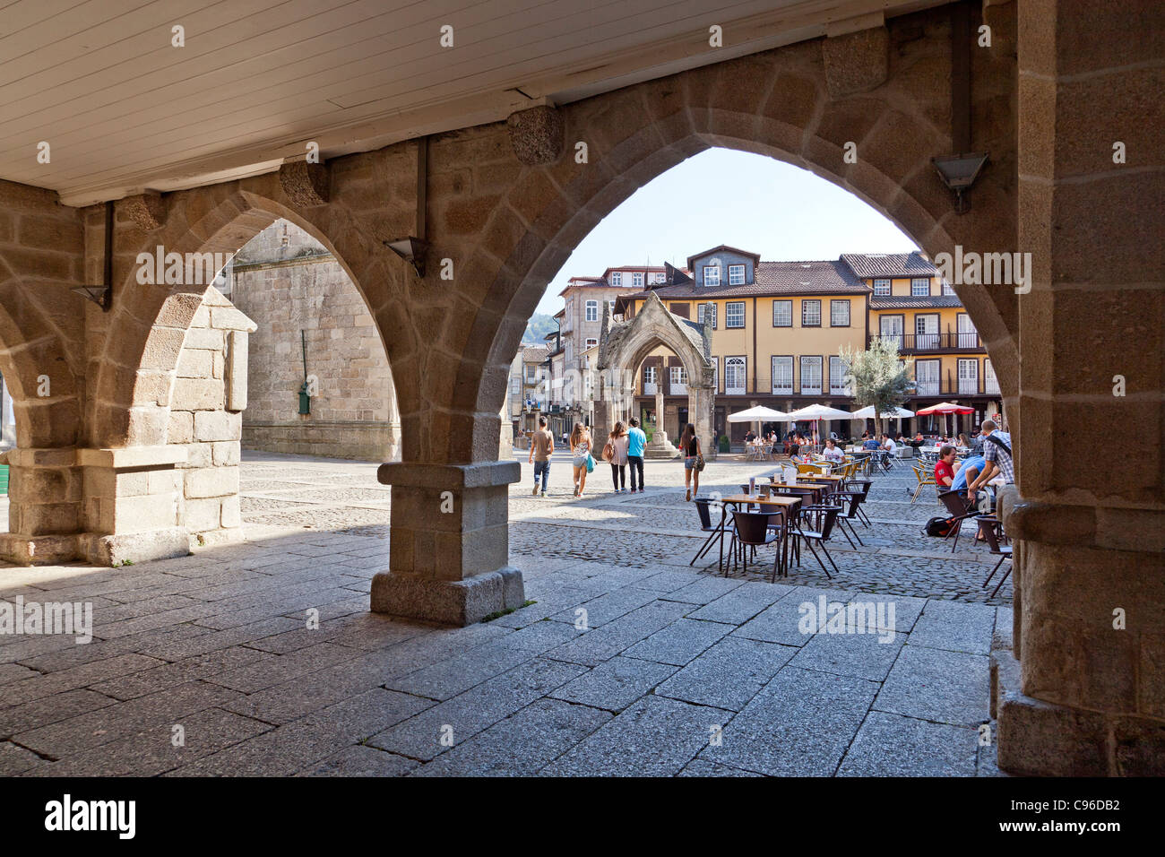 Oliveira Square, Salado monumento e di Nossa Senhora da Oliveira Chiesa visibile attraverso il vecchio Municipio arcade. Guimaraes, Portogallo Foto Stock