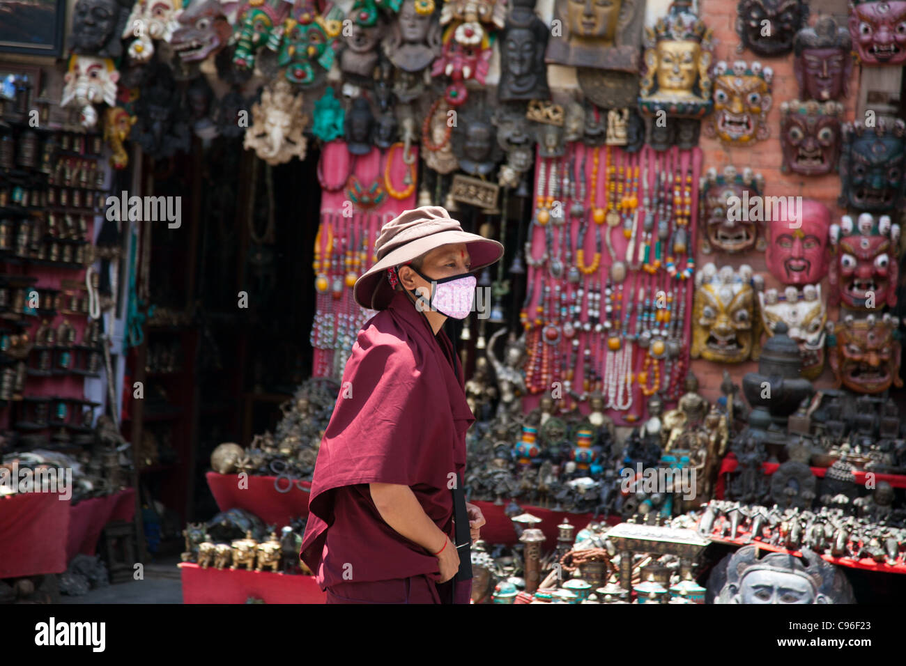 Un monaco buddista presso il Tempio delle Scimmie. Negozio di souvenir per comprare sono sul display. Foto Stock