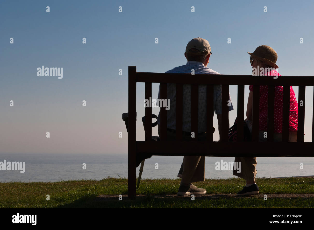 Una coppia di anziani seduti su una panchina sul mare che guarda al mare in Southwold , Suffolk , Inghilterra , Inghilterra , Regno Unito Foto Stock