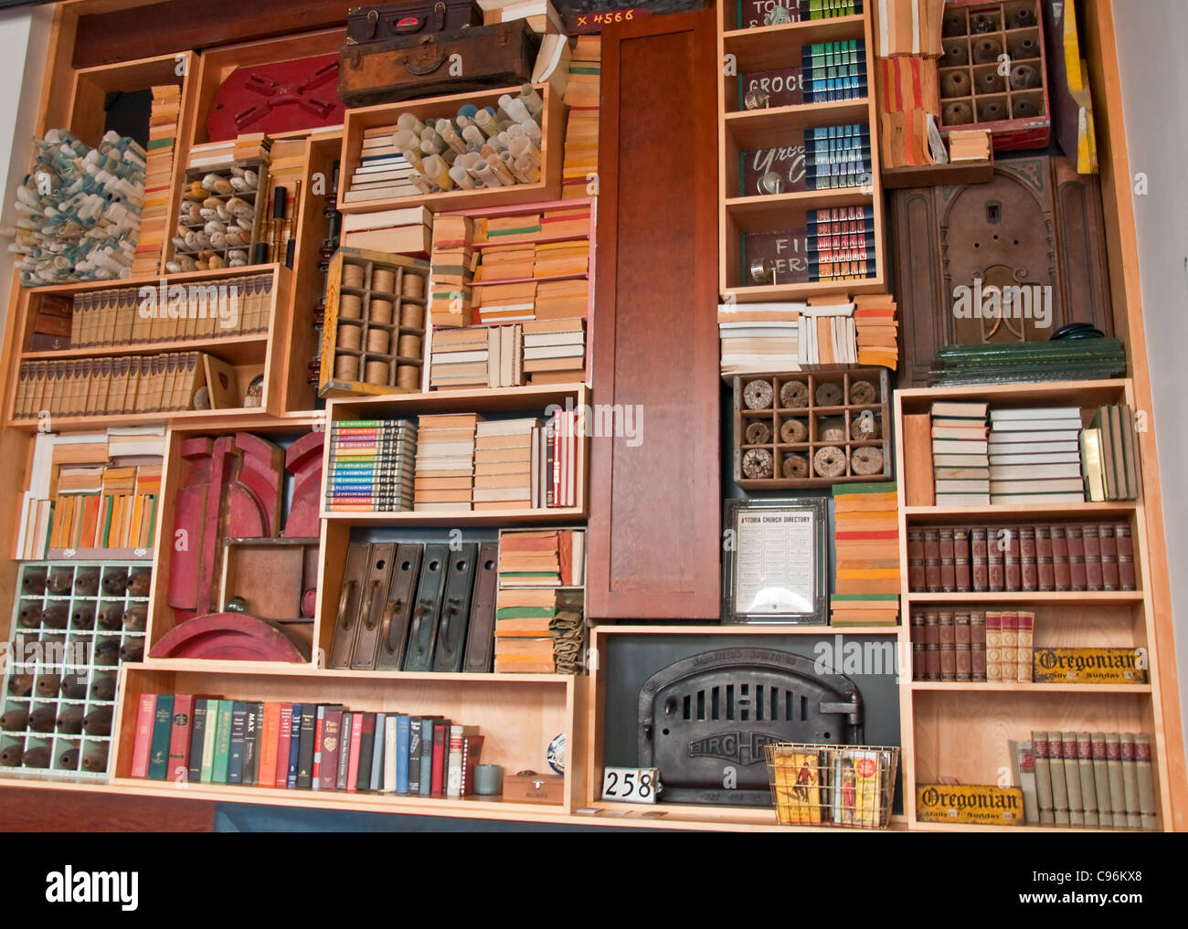 Questa grande annata libreria dispone di libri antichi, vecchie bottiglie di colore marrone, arrotolato mappe e altri oggetti retrò a ripiani. Foto Stock