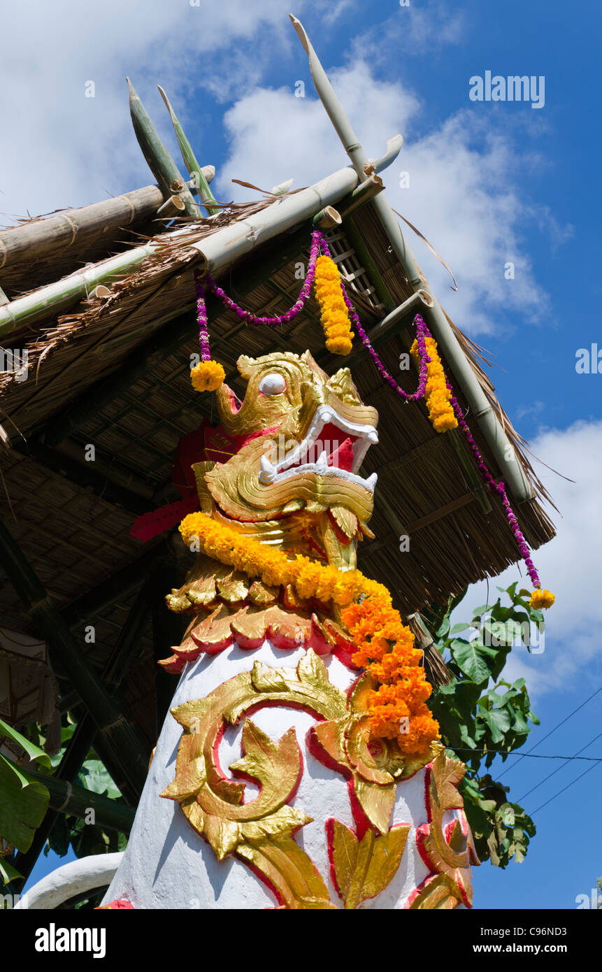 Statua del drago ornati con motivi floreali ghirlande e tetto a spilli sopra di esso al tempio buddista durante il Loi krathong festival in Thailandia Foto Stock