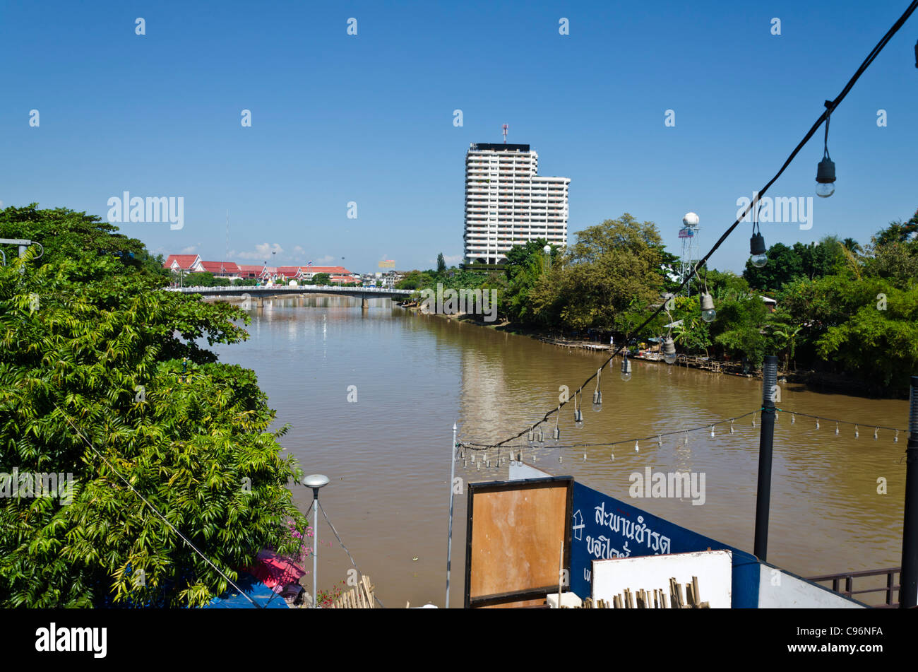 Vista del fiume Ping e una stringa di lampadine in Chiang Mai Thailandia con un ponte e costruire in distanza Foto Stock