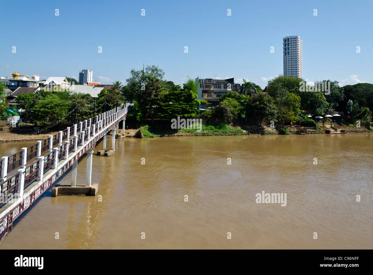 Il Footbridge Attraversamento fiume Ping in Chiang Mai Thailandia e lo sfondo di alberi ed edifici Foto Stock