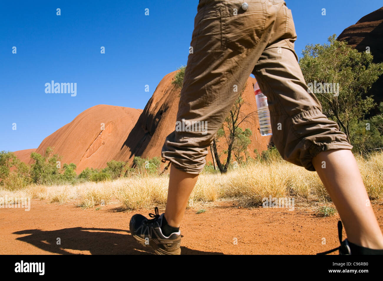 Escursionista su Uluru (Ayers Rock) di base a piedi. Uluru-Kata Tjuta National Park, il Territorio del Nord, l'Australia Foto Stock