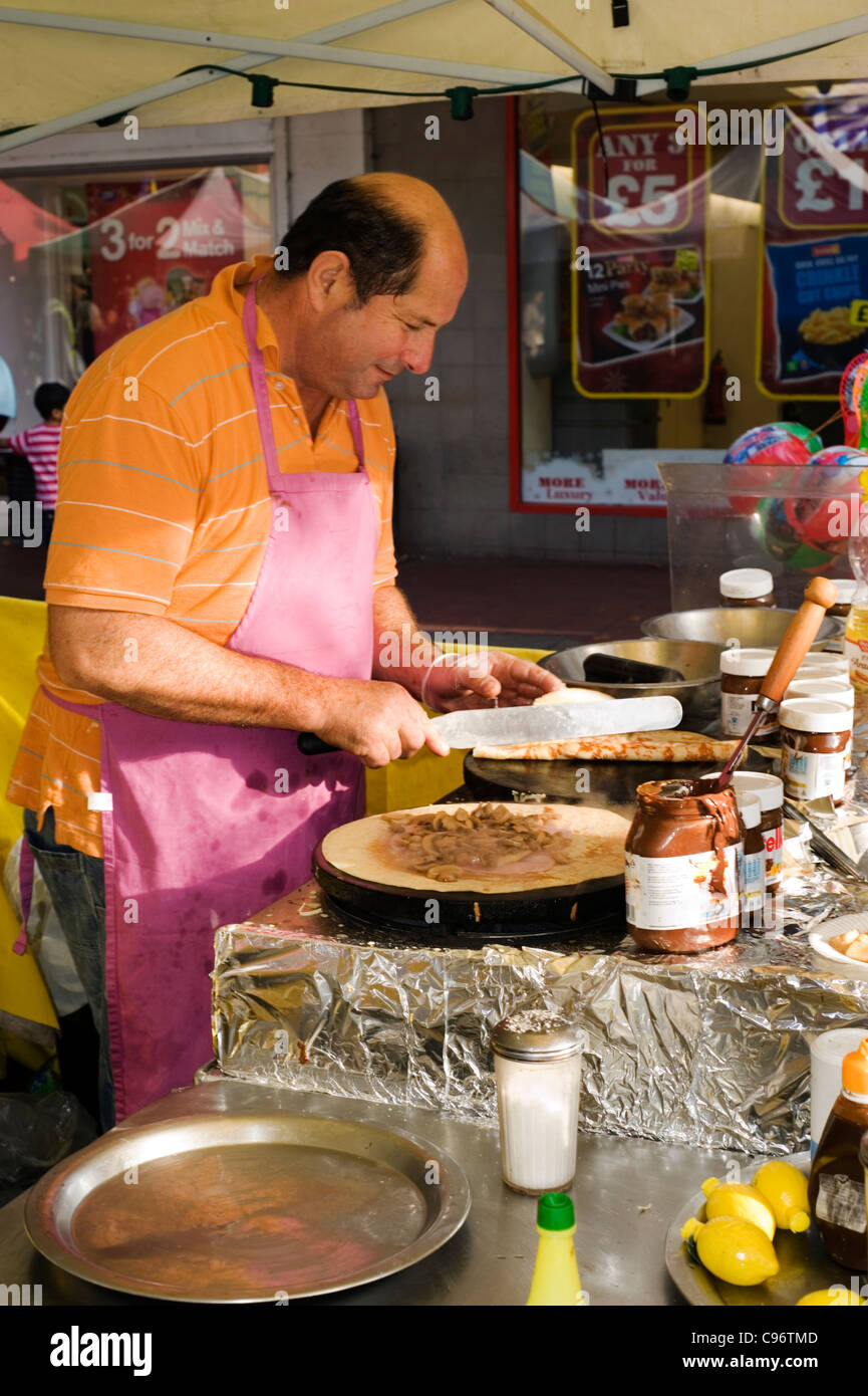 Titolare di stallo rendendo tradizionale crepes francese a un mercato internazionale southsea England Regno Unito Foto Stock