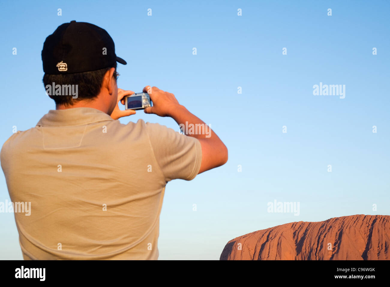 Turistica prendendo una foto di Uluru (Ayers Rock) al tramonto. Uluru-Kata Tjuta National Park, il Territorio del Nord, l'Australia Foto Stock