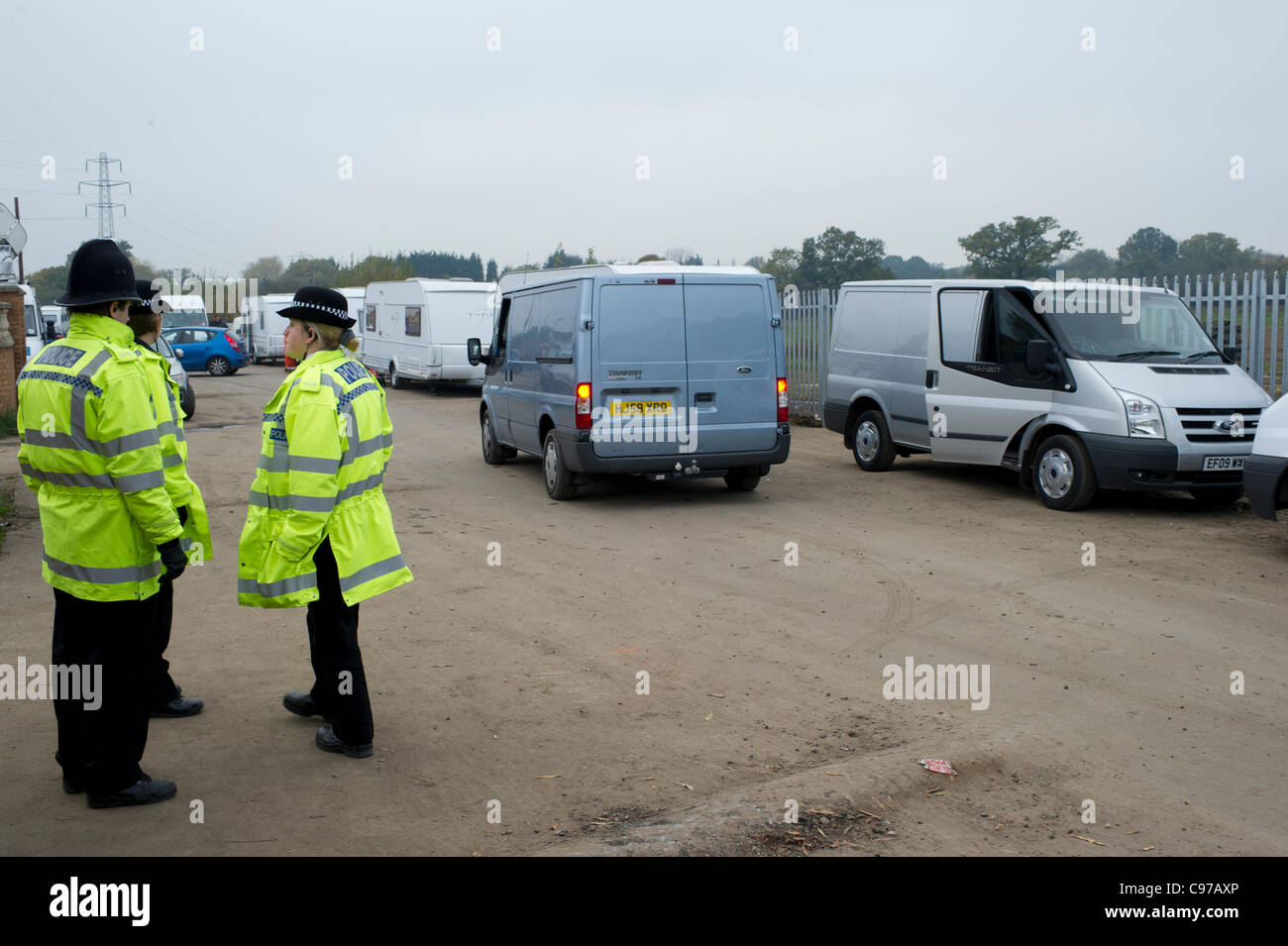 Il 16 novembre 2011. Dale Farm Essex, UK. Consiglio di Basildon i funzionari di polizia hanno partecipato Dale Farm, Basildon, per servire ulteriori avvisi su alcuni viaggiatori che avevano spostato indietro sulla strada sul lato illegale del sito. Gli ufficiali di polizia guarda i veicoli il parcheggio sulla strada in ambito giuridico. Foto Stock