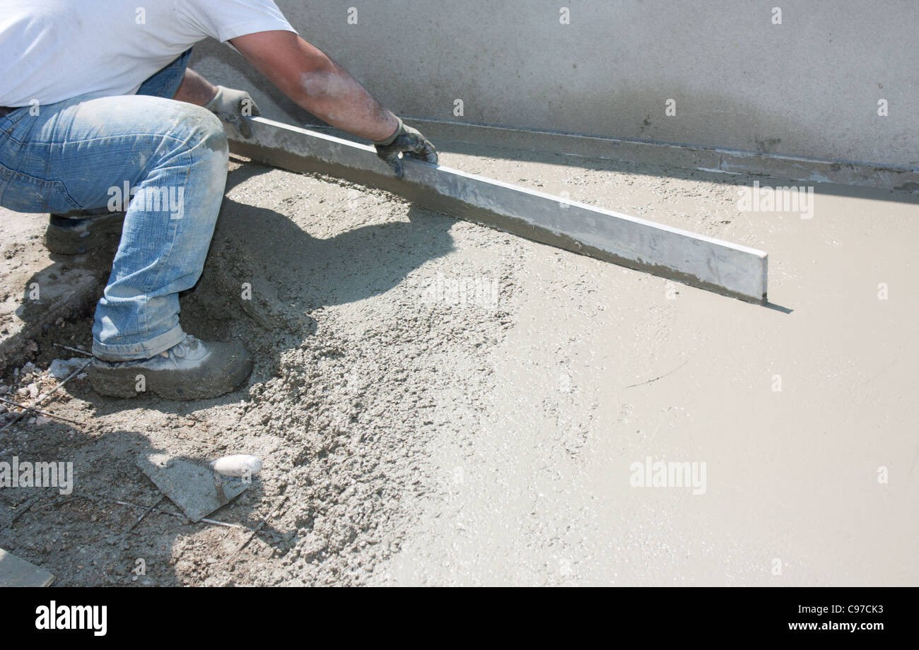 Mason costruire un massetto di cemento di rivestimento Foto Stock