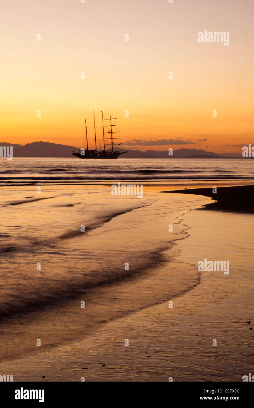 La spiaggia e la vela cruiseship Star Flyer (Star Clippers crociere) al tramonto Puerto Caldera Puntarenas Costa Rica America Centrale un Foto Stock