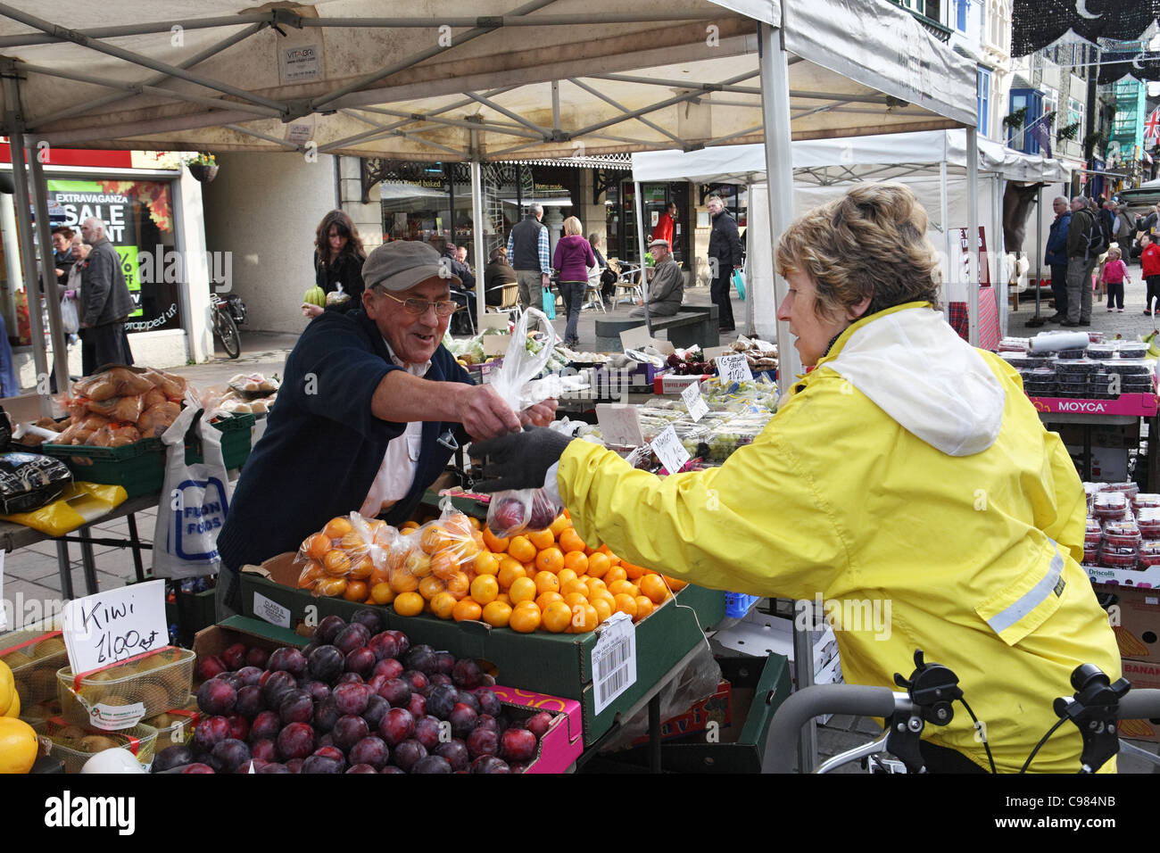 Donna matura comprare la frutta dal mercato in stallo Keswick Lake District inglese, Cumbria, Regno Unito Foto Stock