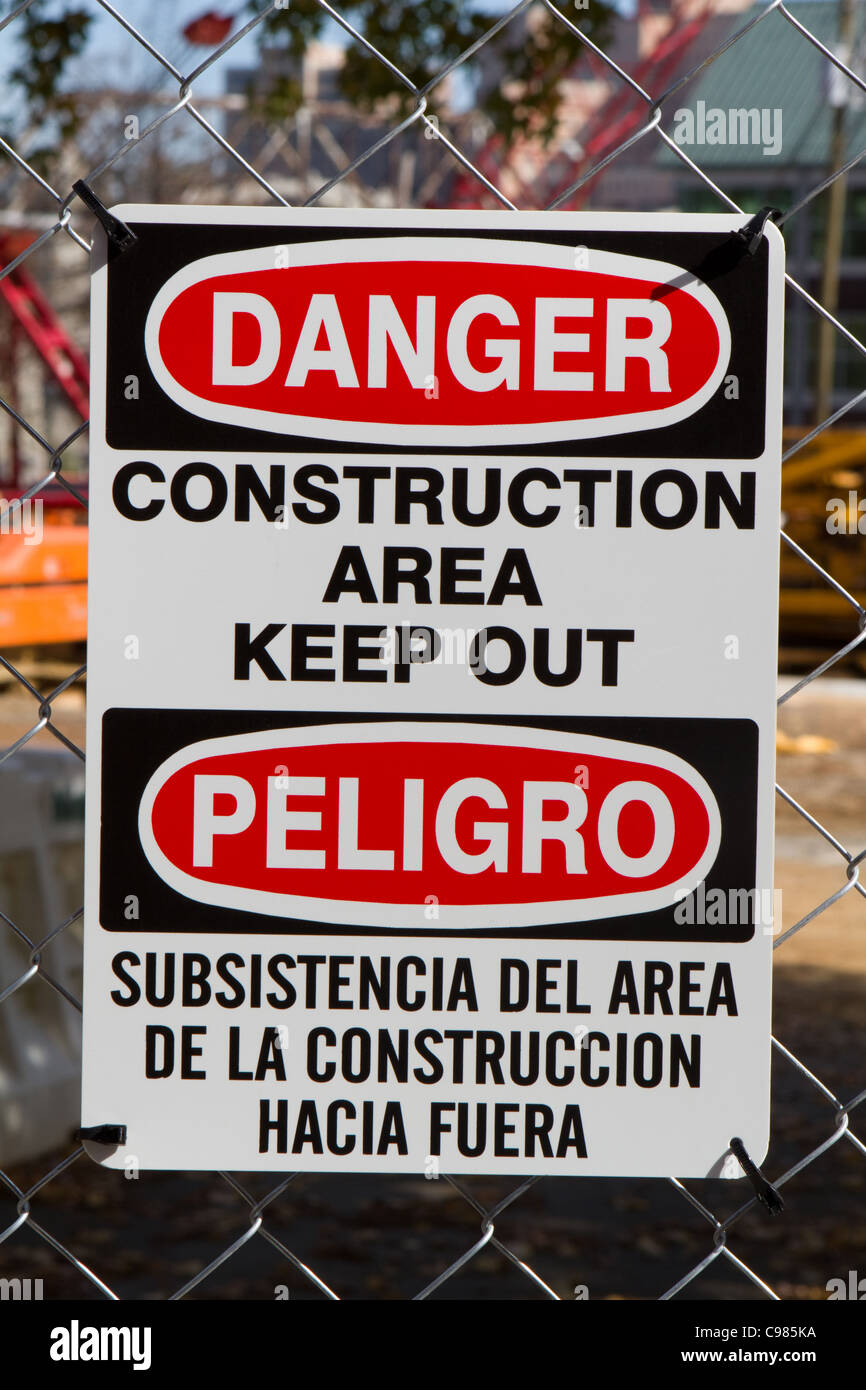 Cartello bilingue sia in lingua inglese che in lingua spagnola per le minoranze avverte di tenere fuori a causa di pericolo sul sito. Foto Stock