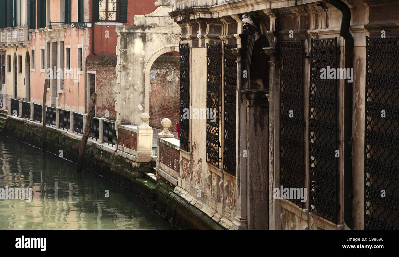 Immagine dei muri delle case in prossimità dell'acqua su un piccolo canale di Venezia. Foto Stock