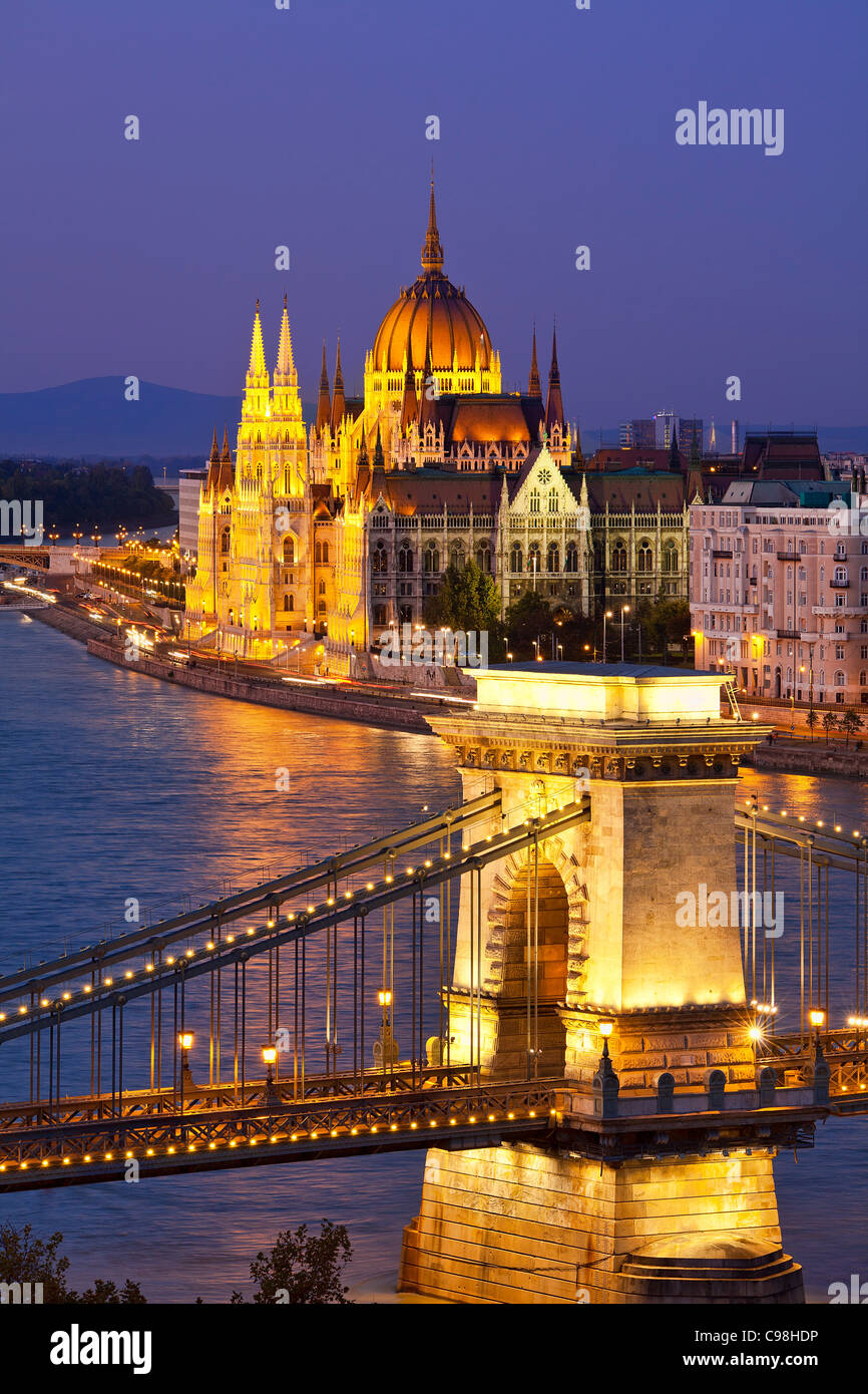 Budapest, catena ponte sul fiume Danubio e il Parlamento ungherese edificio al crepuscolo Foto Stock