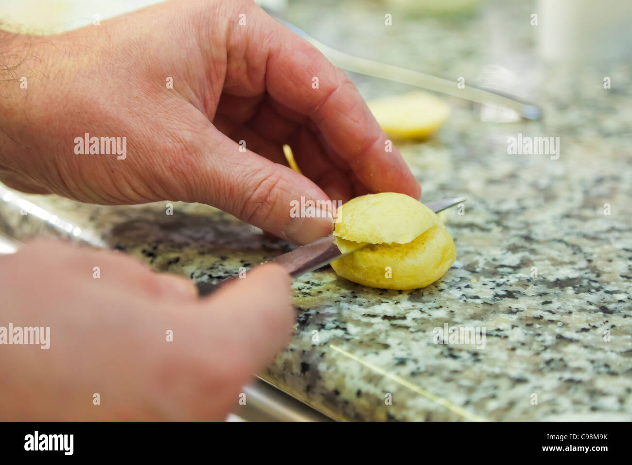 Lo chef tagli una pagnotta per una ricetta speciale., Ristorante Sa Qua na 22, pl. Hamelin Honfleur (14600) Francia TÉL : +33 2 31 89 40 8 Foto Stock