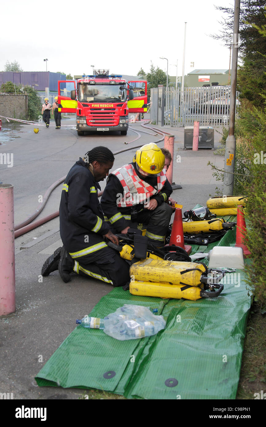 Vigili del fuoco rifornire apparato di respirazione imposta a seguito di un incendio Foto Stock