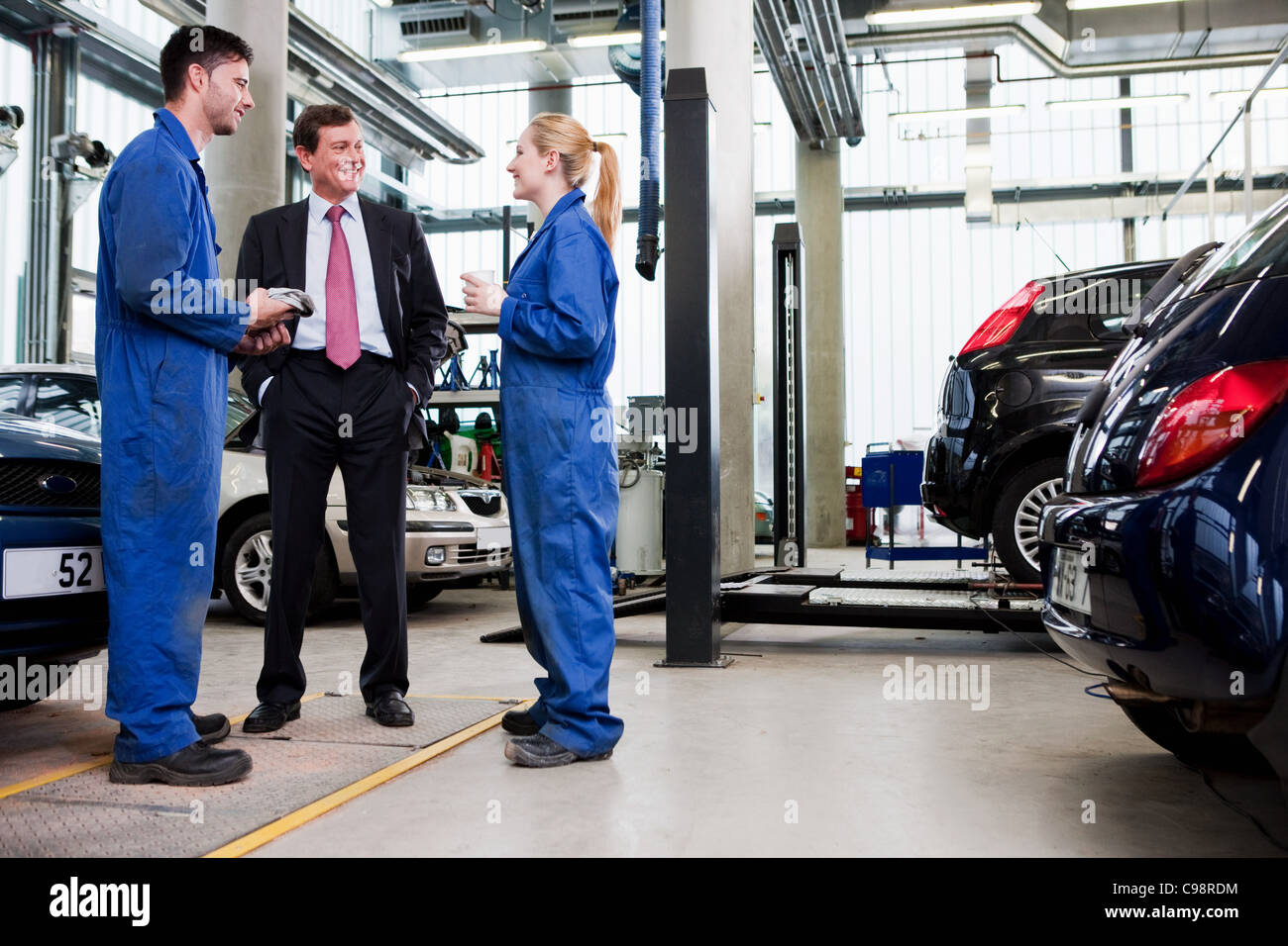 Imprenditore con due auto riparazione meccanica garage Foto Stock