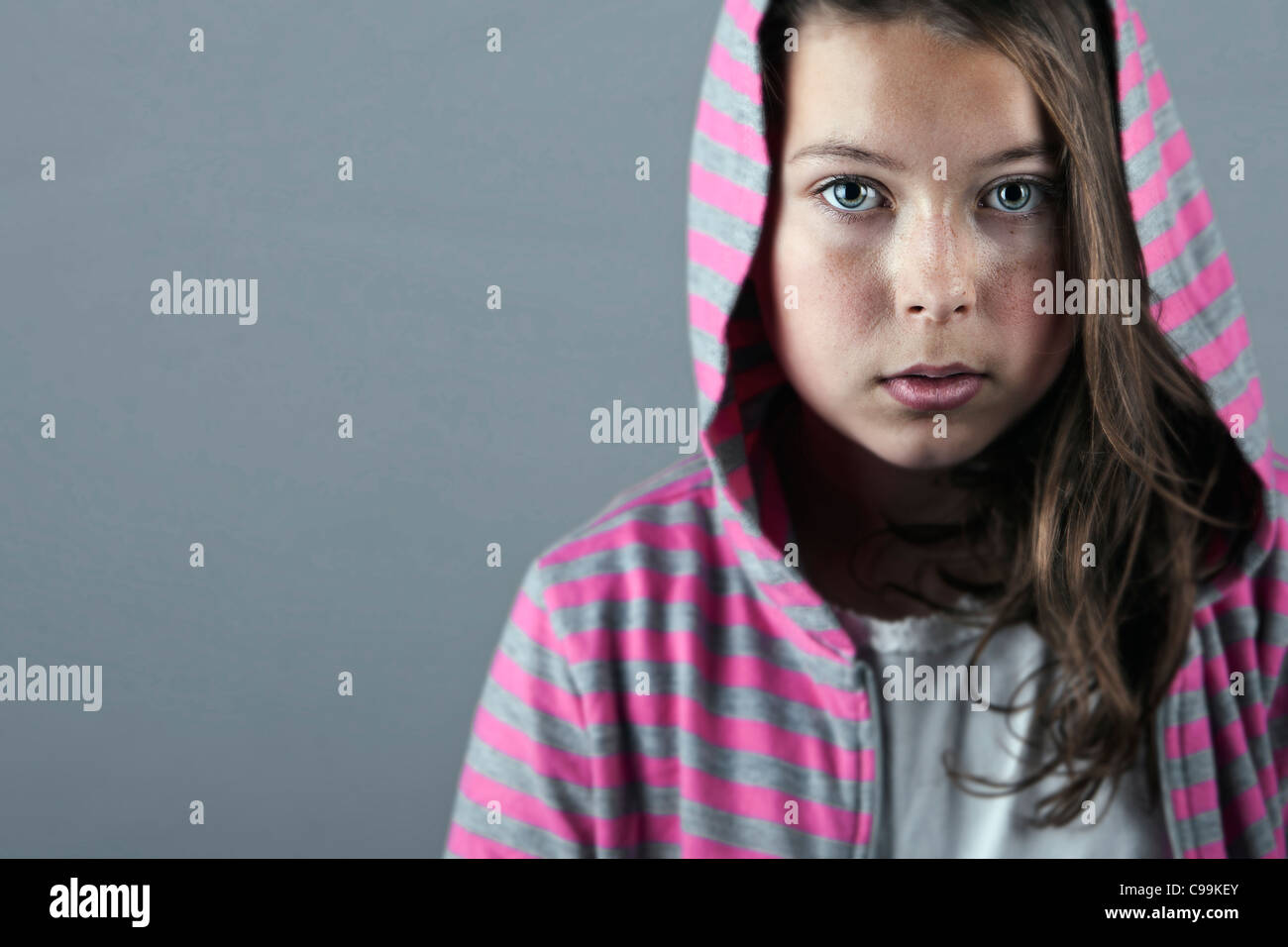 Colpo di un 11 anno vecchia ragazza nella striscia top con cappuccio Foto Stock