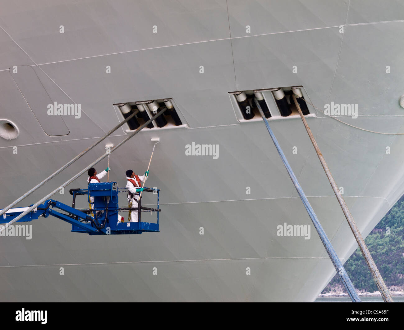 Nave di operai di manutenzione vernice mentre la nave in porto in Skagway,Alaska Foto Stock