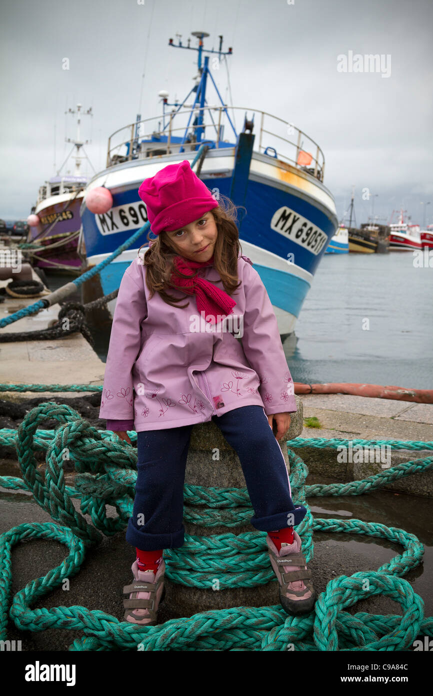 Una giovane ragazza di fronte di un peschereccio da traino Roscoff Bretagna Francia Foto Stock