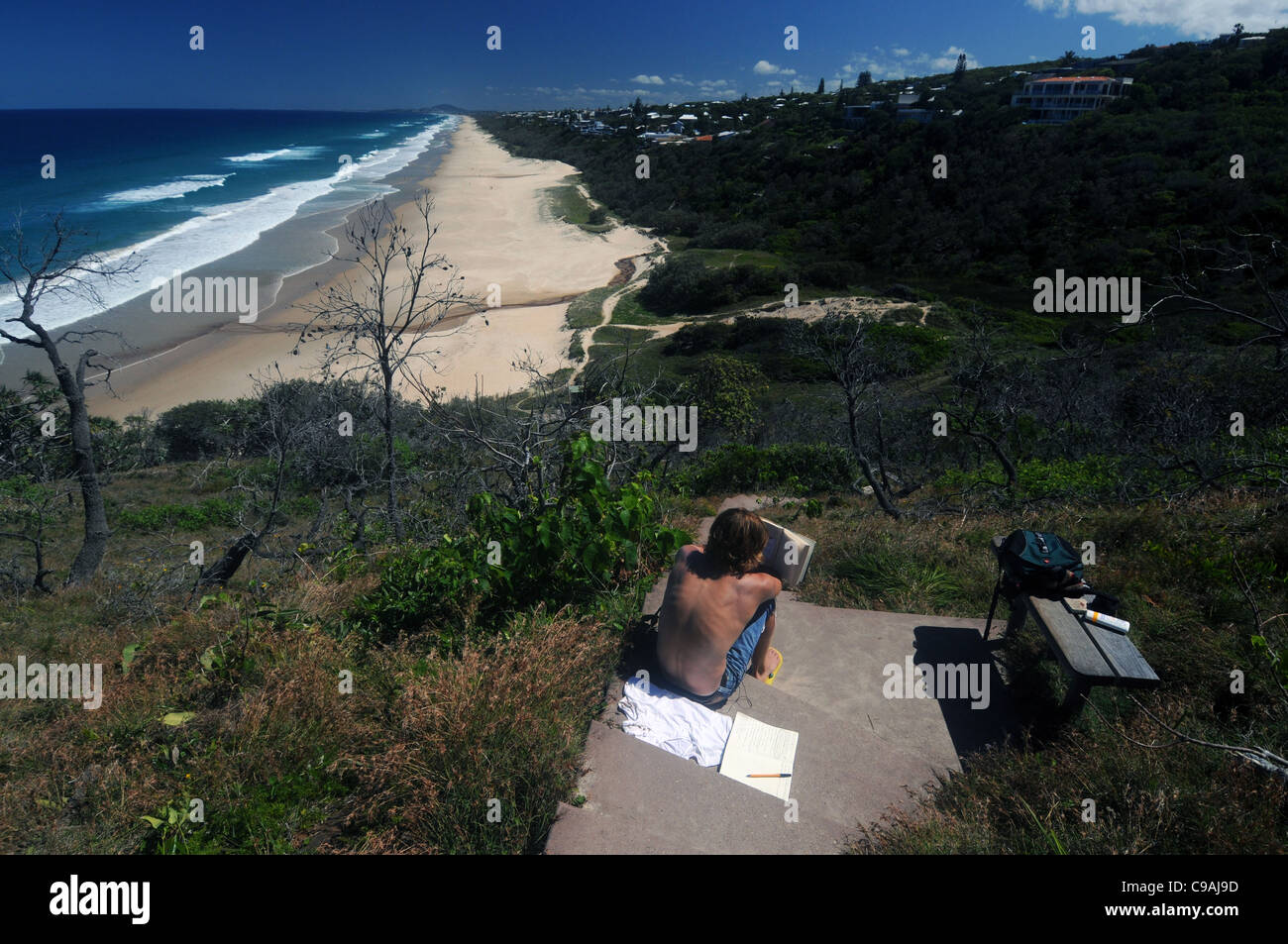 Ragazzo studiare all'aperto con vista sulla spiaggia di sole, Sunshine Coast, Queensland, Australia. No signor o PR Foto Stock
