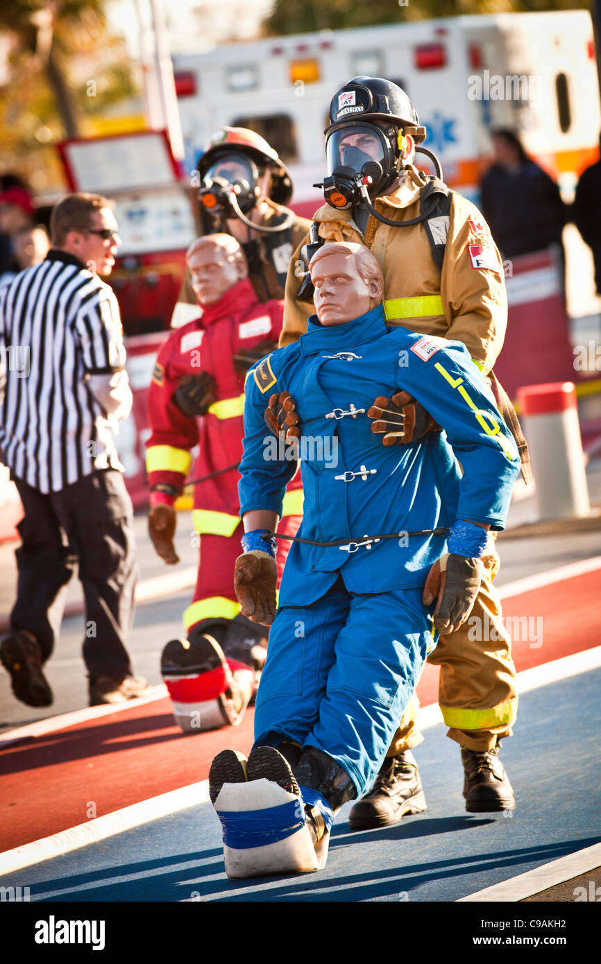 Racing del collo e del collo due vigili del fuoco trascina un 175-pound manichino indietro indossando estinzione completa ingranaggio e lavorano contro l'orologio durante le finali internazionali del pompiere combattimento Challenge il 18 novembre 2011 in Myrtle Beach, Carolina del Sud. Foto Stock