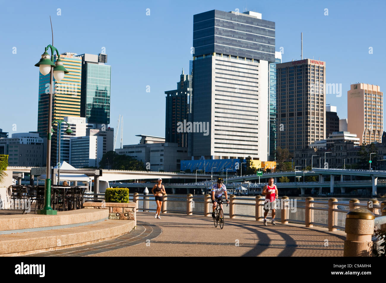 La mattina presto per i ciclisti e per chi ama fare jogging al South Bank Parklands con skyline della città in background. Brisbane, Queensland, Australia Foto Stock