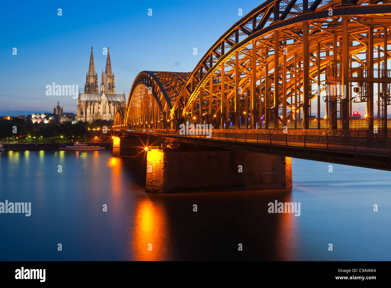 La cattedrale di Colonia e ponte di Hohenzollern dopo il tramonto Foto Stock