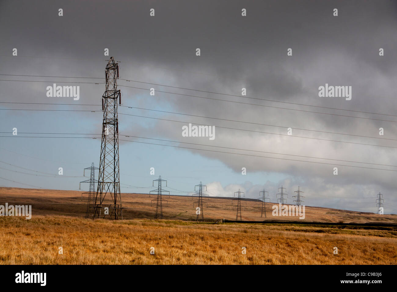 Riga / linea di tralicci che trasportano elettricità su Mynydd Llangattock nella tempesta drammatica luce vicino a Ebbw Vale South Wales UK Foto Stock