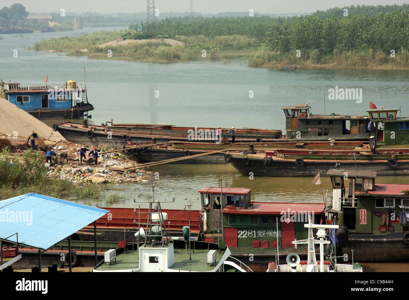 Lavoratori con stanghe per caricare junk su una chiatta a Chizhou, Cina Foto Stock