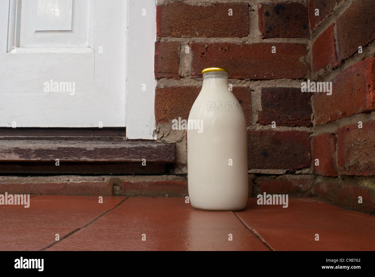 Pinta di birra fresca di latte consegnato su una porta Foto Stock