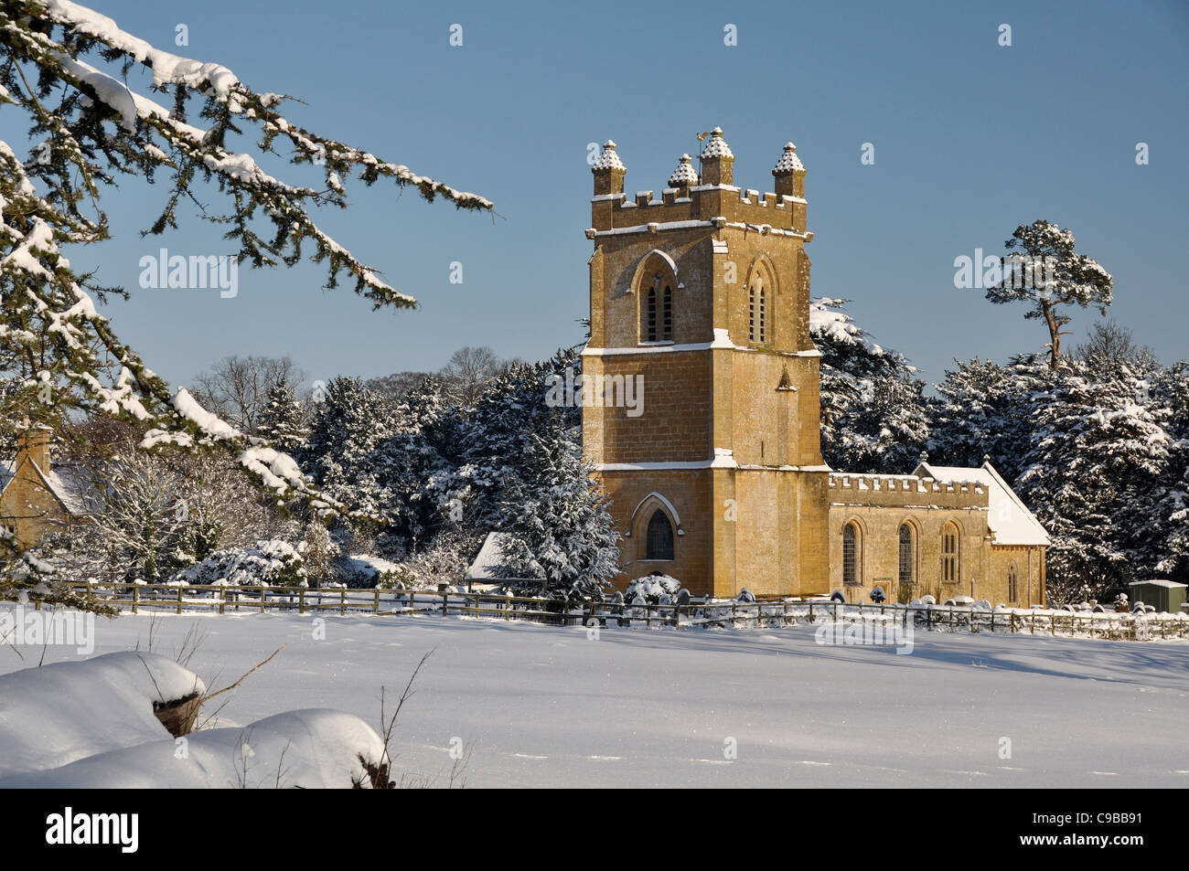 Villaggio costwold chiesa nella neve Foto Stock