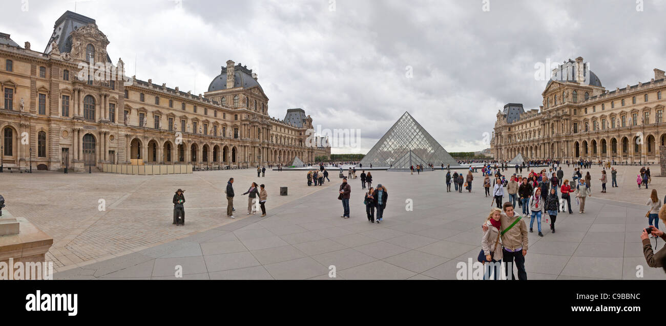 Il Louvre il Musée du Louvre centrale cortile quadrato con i turisti, panorama che mostra la piramide di vetro ingresso Foto Stock