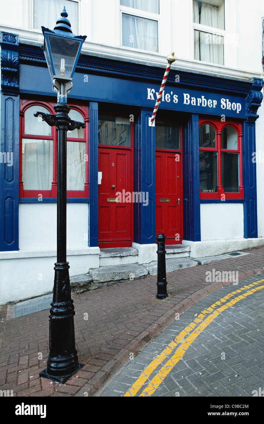 Strada di ciottoli con un vecchio negozio di barbiere, Cobh, nella contea di Cork, Repubblica di Irlanda Foto Stock