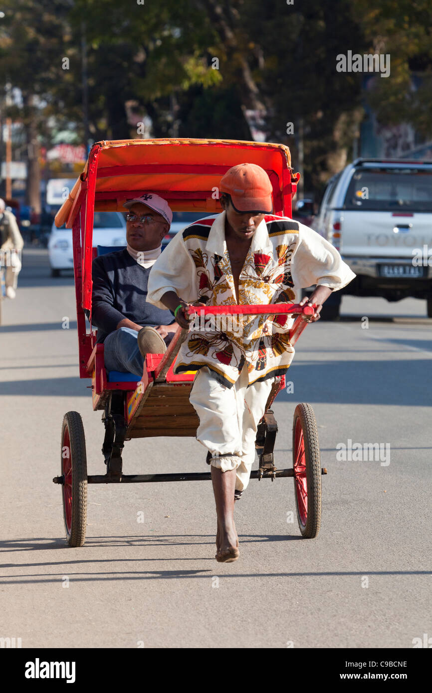 Pousse pousse rickshaws sulla strada di Antsirabe, Madagascar Foto Stock