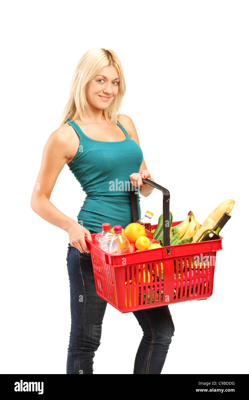 Una giovane donna tenendo un carrello pieno di negozi di generi alimentari Foto Stock