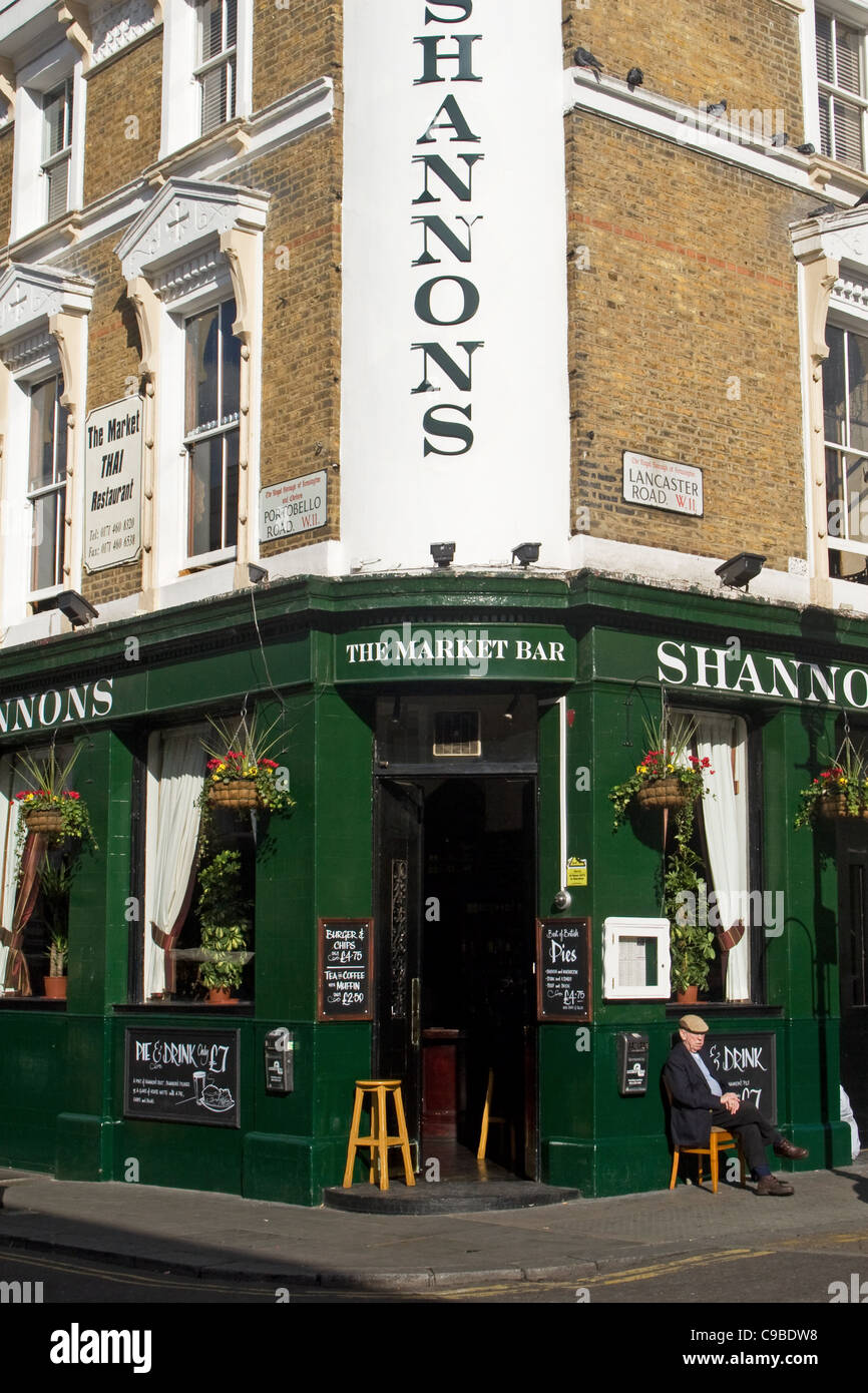 Uomo seduto fuori Shannon's pub, Portobello Road a Notting Hill, Londra, Inghilterra, Regno Unito Foto Stock