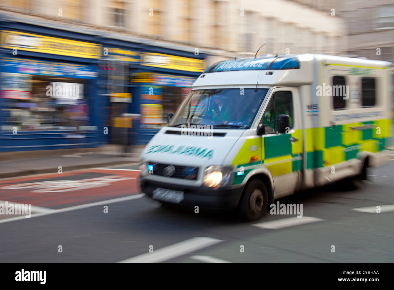 Ambulanza accelerando lungo una strada di città della Scozia UK Foto Stock