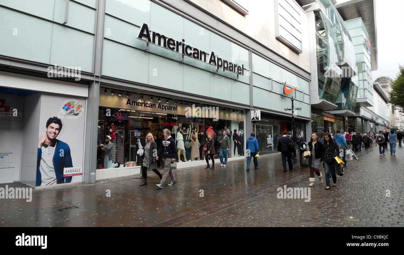I pedoni a piedi passato American Apparel negozio vicino al centro commerciale Arndale nella zona centrale di Manchester, Inghilterra, Regno Unito KATHY DEWITT Foto Stock