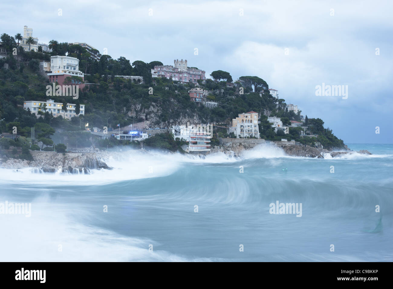 Luce del giorno esposizione di un mare ruvido che colpisce un promontorio roccioso. Nizza, Costa Azzurra, Francia. Foto Stock