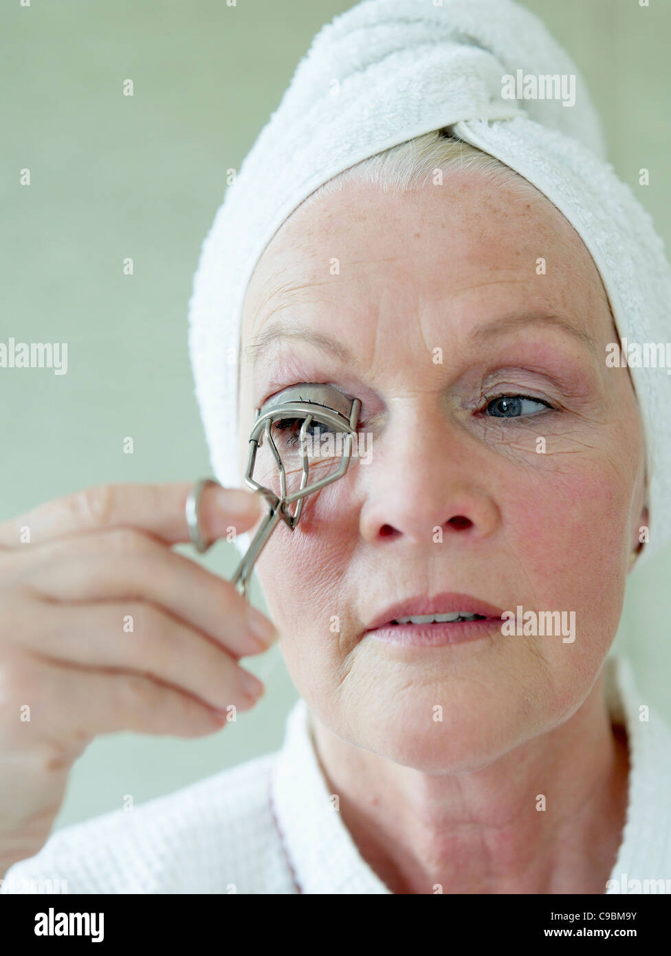 Senior donna la sagomatura di ciglia con ciglia, arricciatore close up Foto Stock