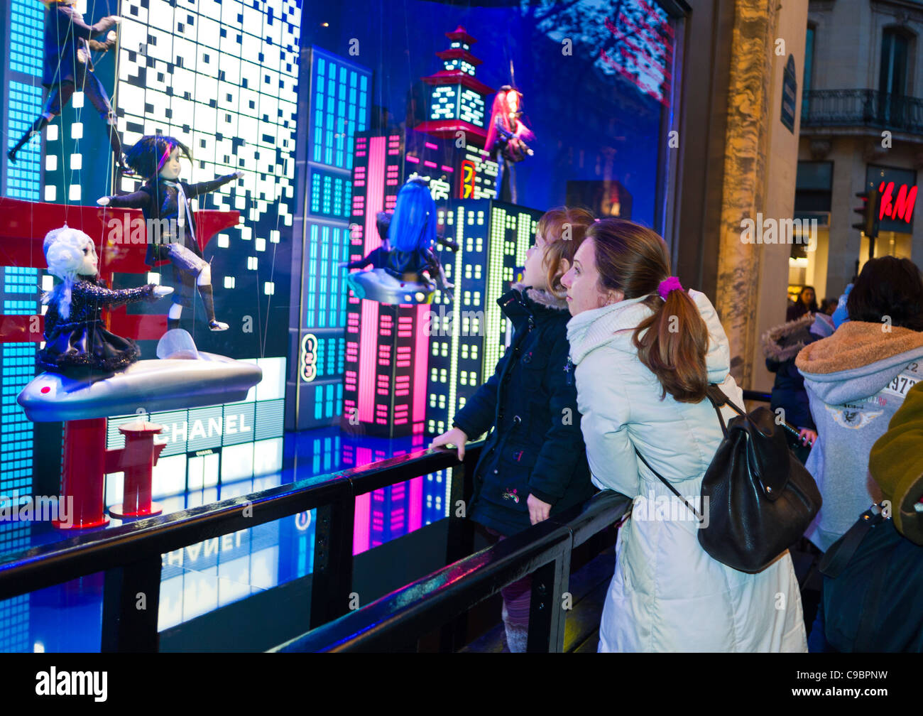 Parigi, Francia, mamma con bambini che guardano sul fronte dei grandi magazzini le Printemps, vetrina, spettacoli di luci di Natale, di notte, famiglie a natale, mamma che fa shopping con la figlia Foto Stock